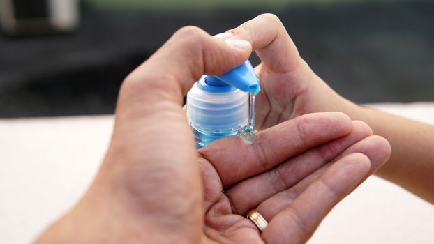 Washing hands with alcohol based gel from a hand pump bottle to protect against corona virus or Covid-19.