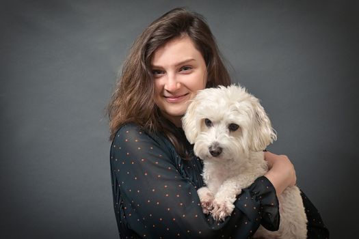 Teen Girl With Maltese Dog In Her Hands in Studio
