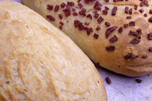 Fresh home baked breads, make out of wheat, one simple and one with pepperoni on top