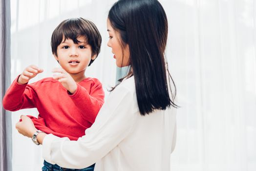 Asian happy beautiful mother getting dressed clothes on her kids for going to school