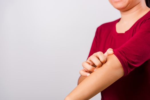 Asian beautiful woman itching her scratching her itchy arm on white background with copy space, Medical and Healthcare concept