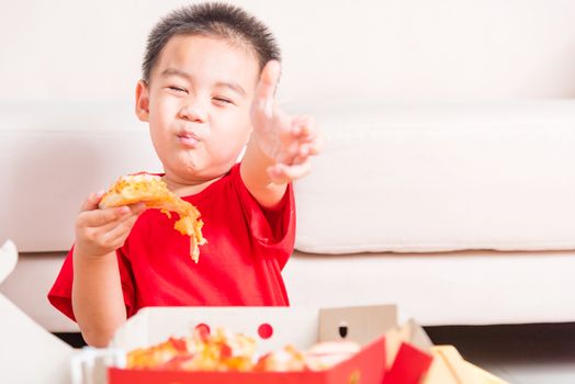 Hot Homemade, Vegetarian fast Italian food, Cute Little Child enjoying eating Delivery Pizza pepperoni, cheese many slices deliciously and show good finger thumb for like in a cardboard box at home