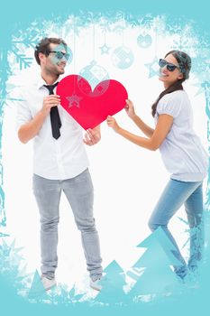 Hipster couple smiling at camera holding a heart against christmas frame