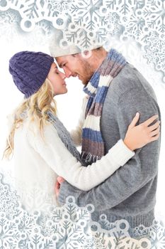 Attractive couple in winter fashion hugging against snowflakes on silver