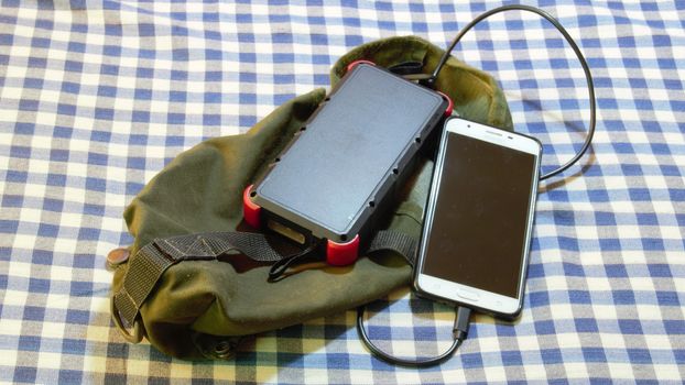army solar power bank in survival pouch used to recharge cell mobile phone