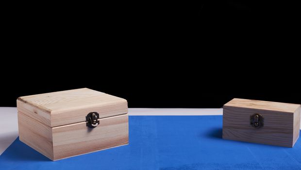 Wooden boxes on black background and blue mat. Secrets