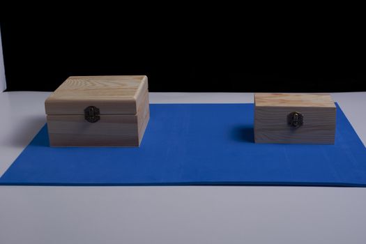 Wooden boxes on black background and blue mat. Secrets