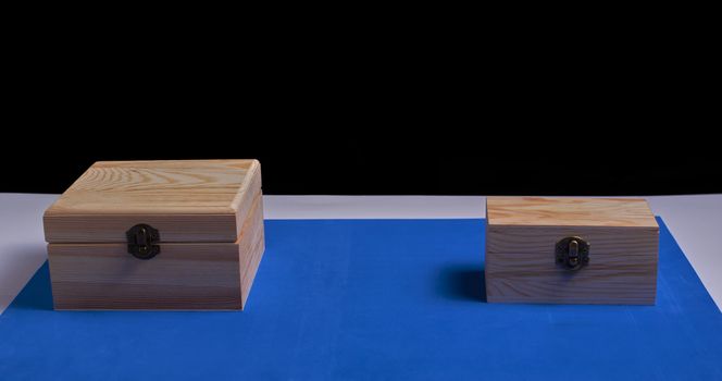 Wooden boxes on black background and blue mat. Secrets