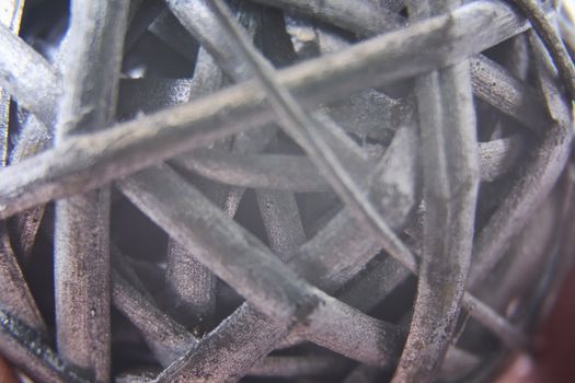 Macro photography of ball made of silver painted straw, closeup and detail of straw