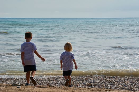 Children looking at the calm and blue beach