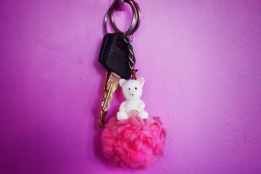 A pair of bike keys with a cute pink colored doll key ring
