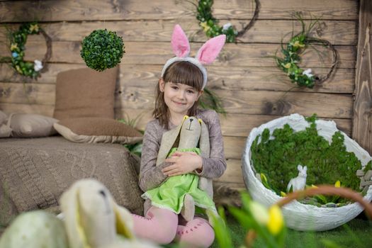 Child girl with Easter eggs in decorated studio