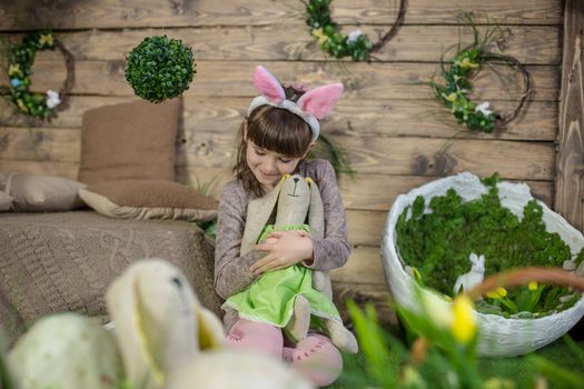 Child girl with Easter bunny in decorated studio