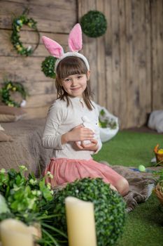 Child girl with Easter eggs in decorated studio