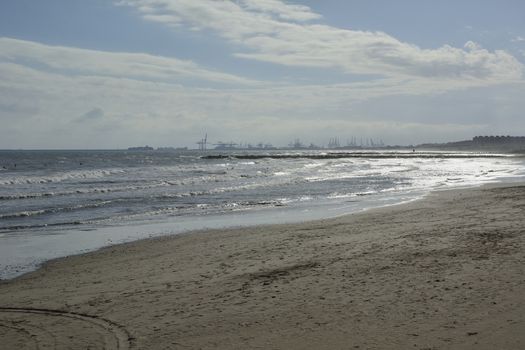 The port cranes seen from the beach. Machine colors