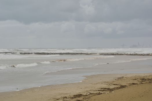 Groyne and port cranes in a big storm. Colors of nature