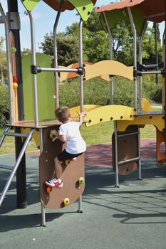 Little boy playing in a playground. Colors of persons