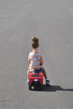 Boy in striped shirt playing with toy car. Colors of persons