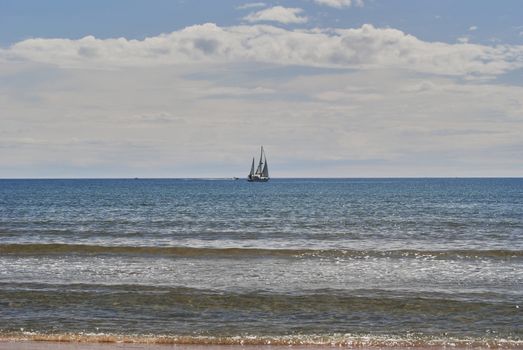 Sailboat sailing through the sea on a bright and calm day. Colors of nature