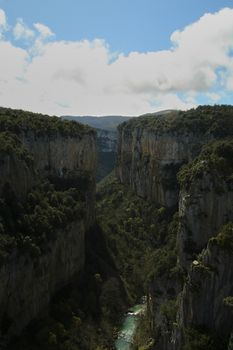 Two steep mountains in the middle of the forest, Blue sky with white clouds and straight walls