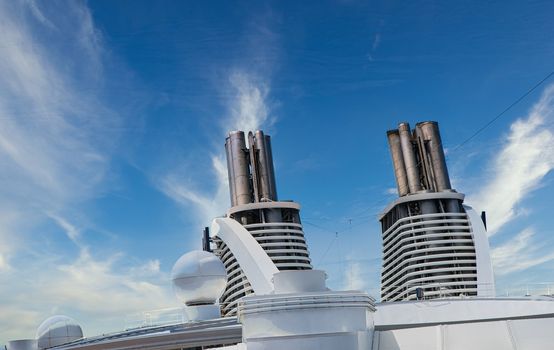 Twin Diesel smokestacks on a luxury cruise ship under nice sky