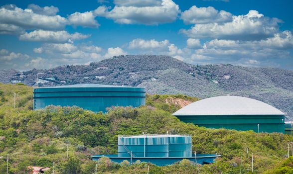 Green and blue water tanks on a green tropical hill on St Thomas