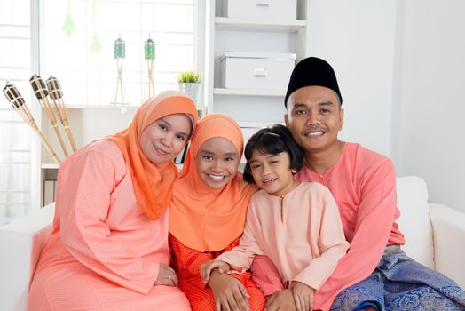 Happy Malay family portrait in traditional clothing during Hari Raya. Malaysian family lifestyle at home.