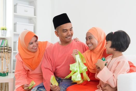 Happy Malay family portrait in traditional clothing during Hari Raya. Malaysian family lifestyle at home.