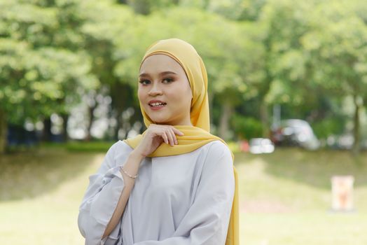 Portrait of cheerful Muslim girl in hijab, smiling at outdoor.