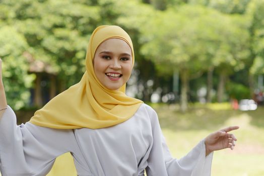 Portrait of cheerful Muslim girl in hijab, smiling at outdoor.