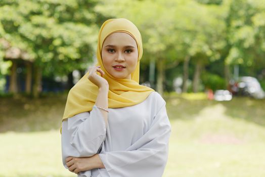 Portrait of cheerful Muslim girl in hijab, smiling at outdoor.