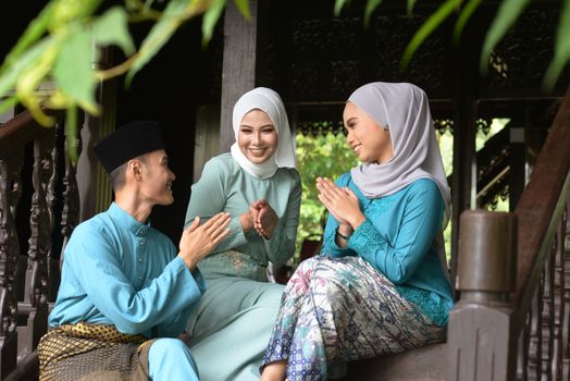 Asian Malay Muslim greetings during Hari Raya Aidilfitri. Malaysian people living lifestyle.