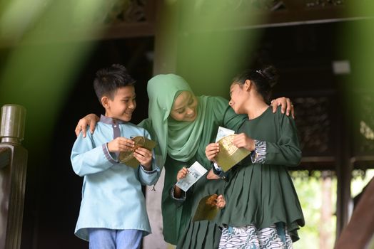 Muslim family, children received money packet as blessing, Hari Raya Eid Al-Fitr concept. 