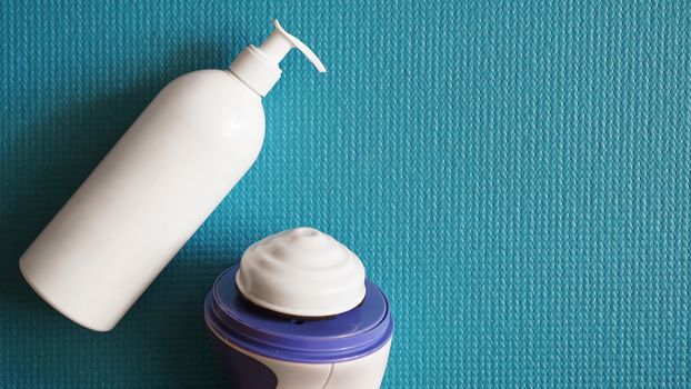 Lotion and anti-cellulite massager on a blue background. Healthy and beautiful skin concept.