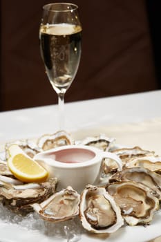 Opened fresh oysters with lemon on dish. Shallow dof.