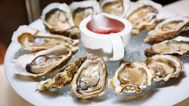 Opened fresh oysters with lemon on dish. Shallow dof.