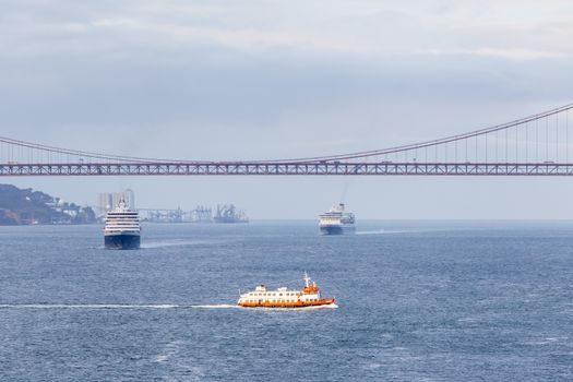 Ships and boats traverse the River Tagus beside the port of Lisbon in Portugal.