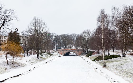 A winter view along a frozen Riga canal.  The canal flows through Bastion Hill park in Riga, Latvia.