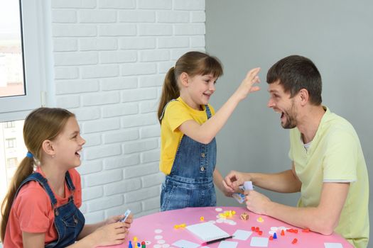 Daughter is going to punch dad in the forehead for a loss in a board game