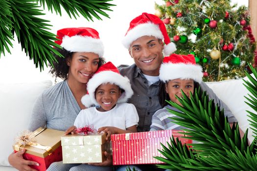 Composite image of family holding Christmas presents against digitally generated fir tree branches