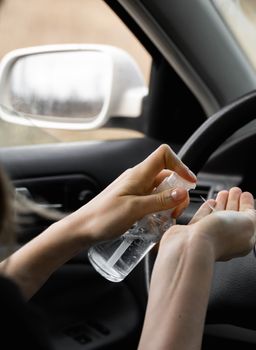 Woman is using antiseptic for protect himself from bacteria virus while planning to drive. Antiseptic while quarantine, pandemic, covid 19, coronavirus, infection