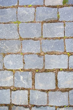 Old aged granite paving stones. Texture of old granite paving stones. The texture of the pavement granite pattern wallpaper for design. Rough texture vertical
