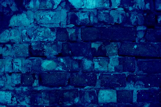 Destroyed brick wall of red bricks, texture in trendy blue 2020 color