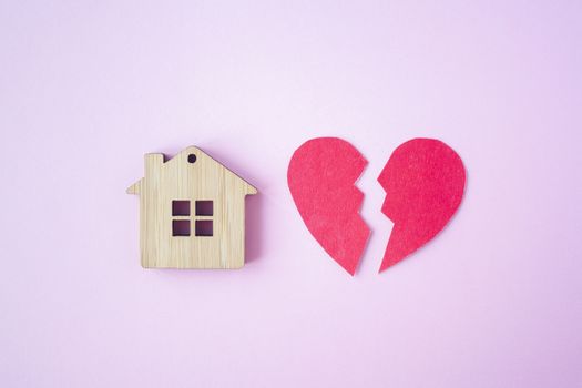 Divorce, division of property, poverty and no money concept. Wooden house with broken heart on bright pink background. Mortgage, rent, realtor