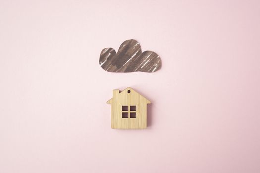 Paper dark cloud above the wooden house. Bad times, mortgage, no money concept. Flat lay. Top view