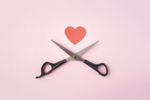Scissors with red heart top view on pink background. Concept of divorce. Divorce proceedings, law, court, family break, pain