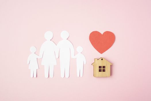 Happy paper family with house and red heart on pink background. Love and family union concept. 