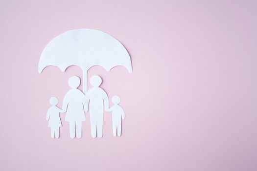 Concept of Social Protection Family. Paper cut Family Under Umbrella on bright pink background. Life insurance, family protection