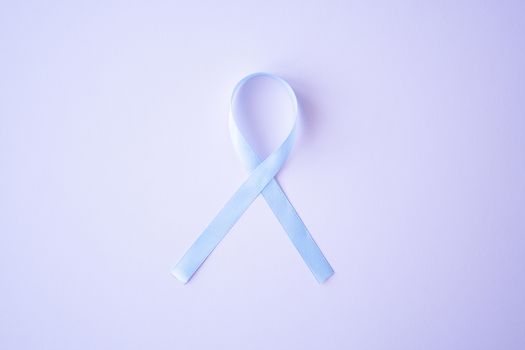 Prostate cancer awareness blue ribbon on pink background. Men healthcare concept, men carcinoma symbol.