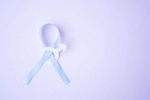 Prostate cancer awareness blue ribbon with white paper male sign mars arrow copy space on pink background. Men healthcare concept, men carcinoma symbol.